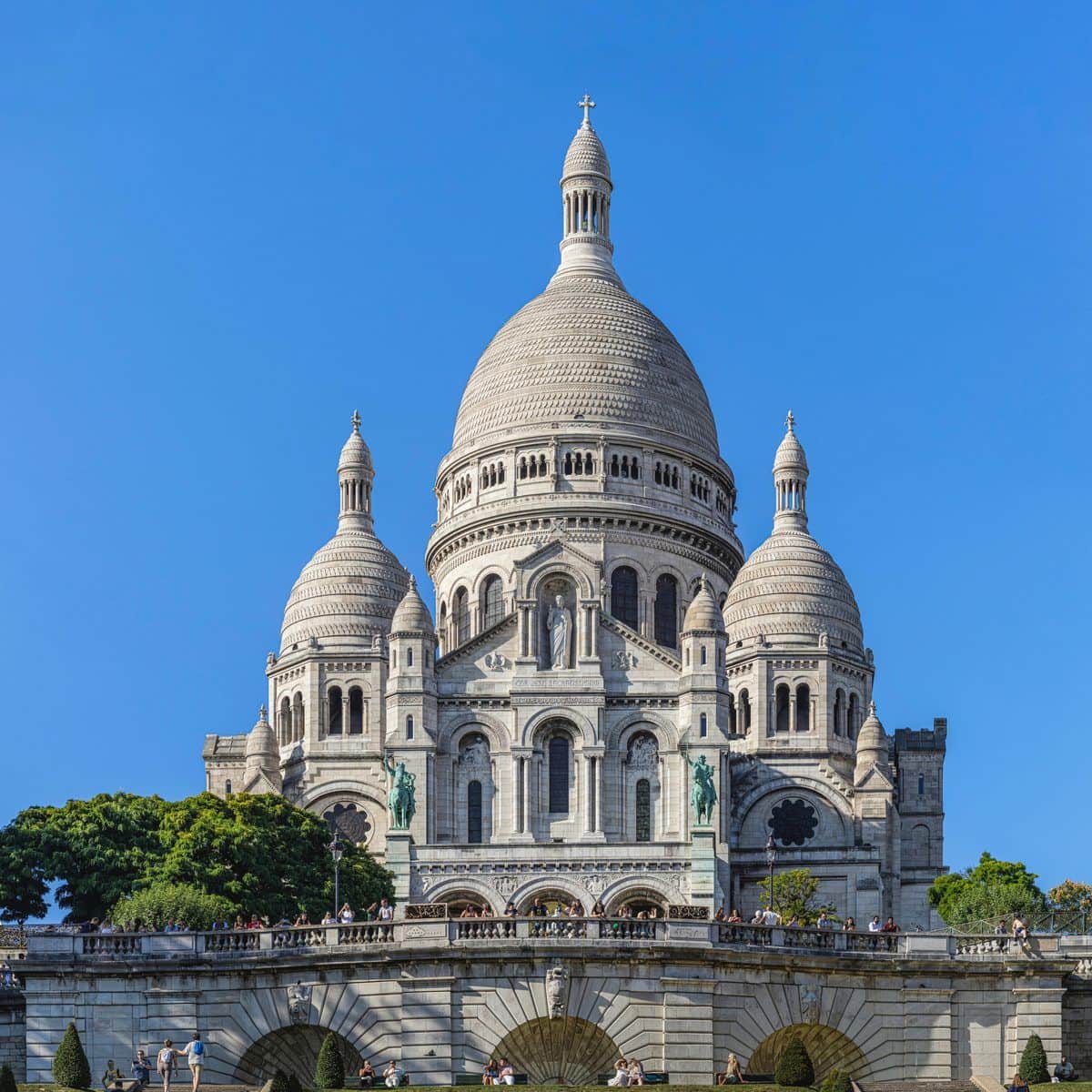 Las cúpulas blancas de la basílica del Sacré-Cœur en Montmartre bajo un cielo azul despejado