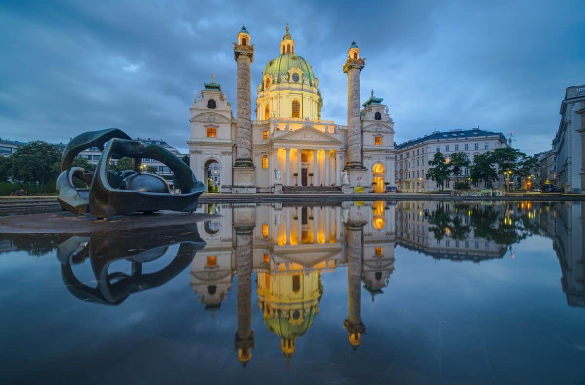 La Karlskirche de Viena al anochecer, reflejada en el estanque de la Karlsplatz